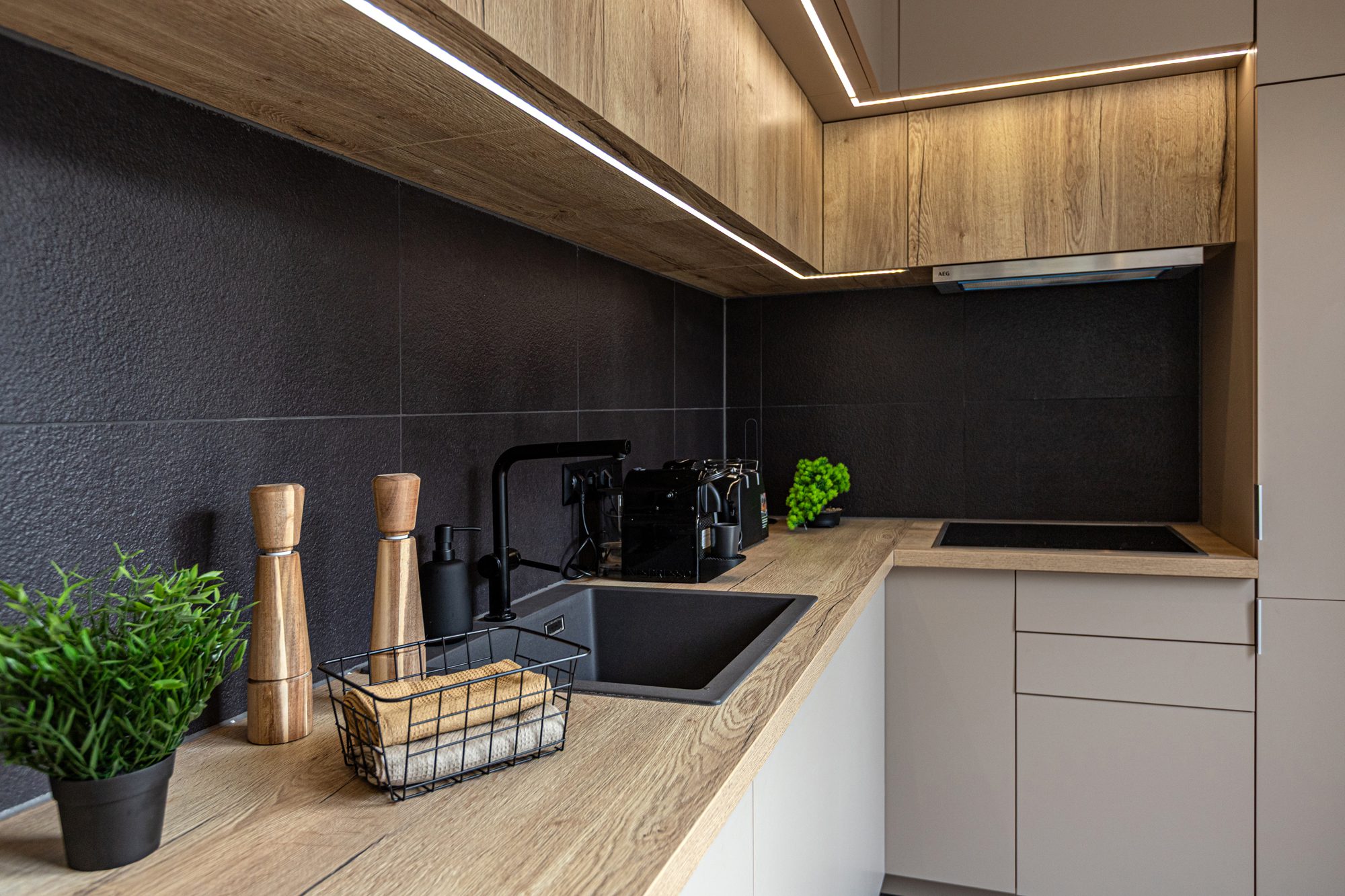 Fully equipped kitchen villa rental Lake Balaton - Villa Porta Verde I modern kitchen with dark grey backsplash and wood cabinets