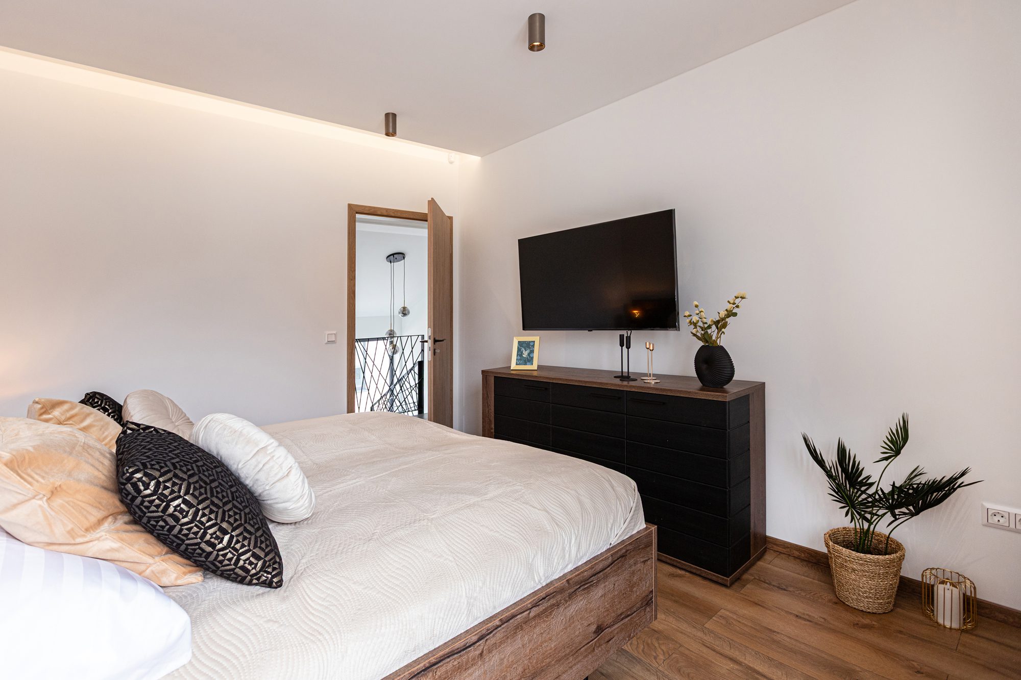 Bedroom villa Balatonalmádi Hungary - Villa Porta Verde I bedroom with pillows, dresser, TV and decorative items