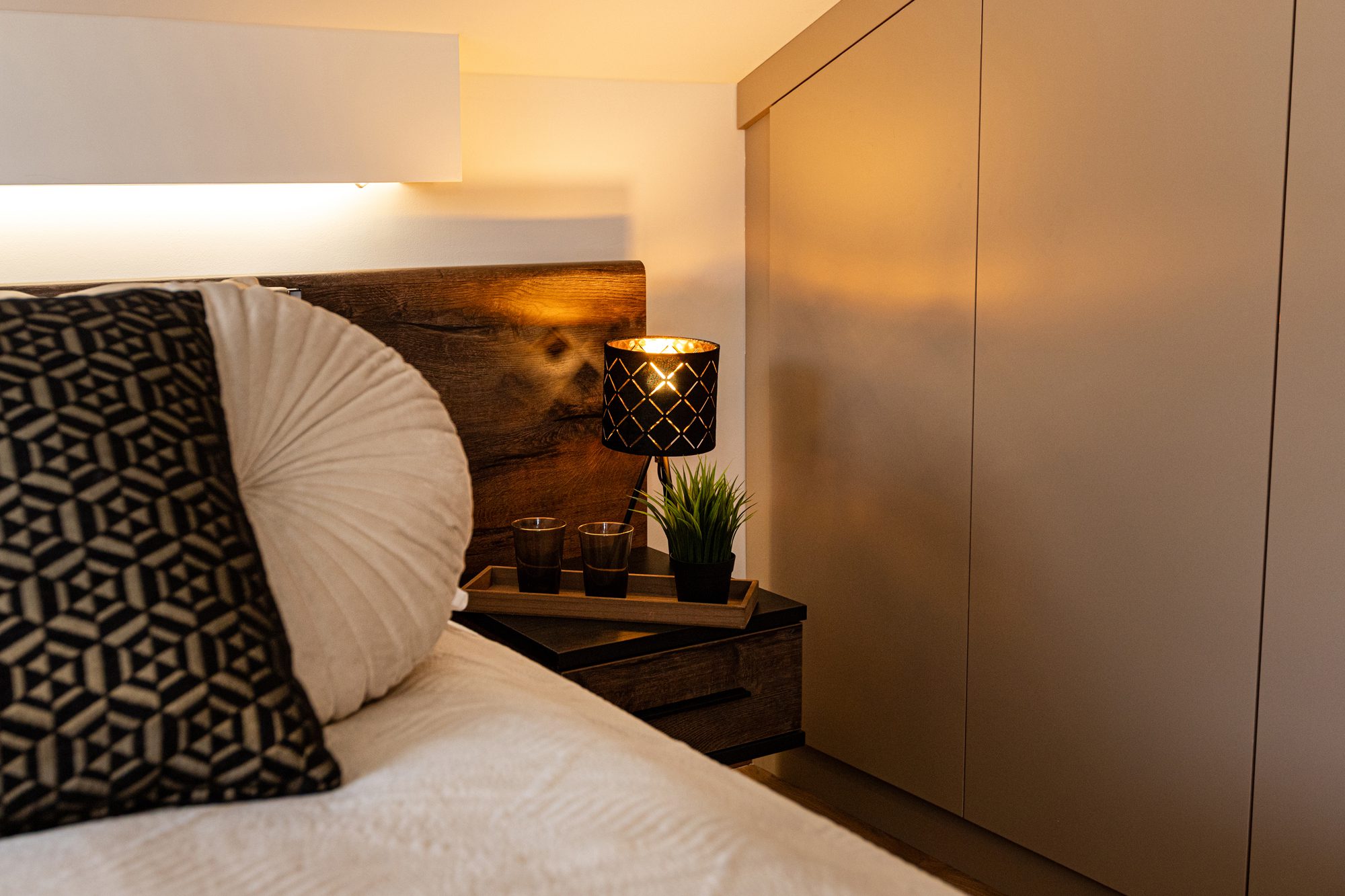 Bedroom villa Balatonalmádi - Villa Porta Verde I bedroom with dark headboard, bedside table and built-in wardrobe