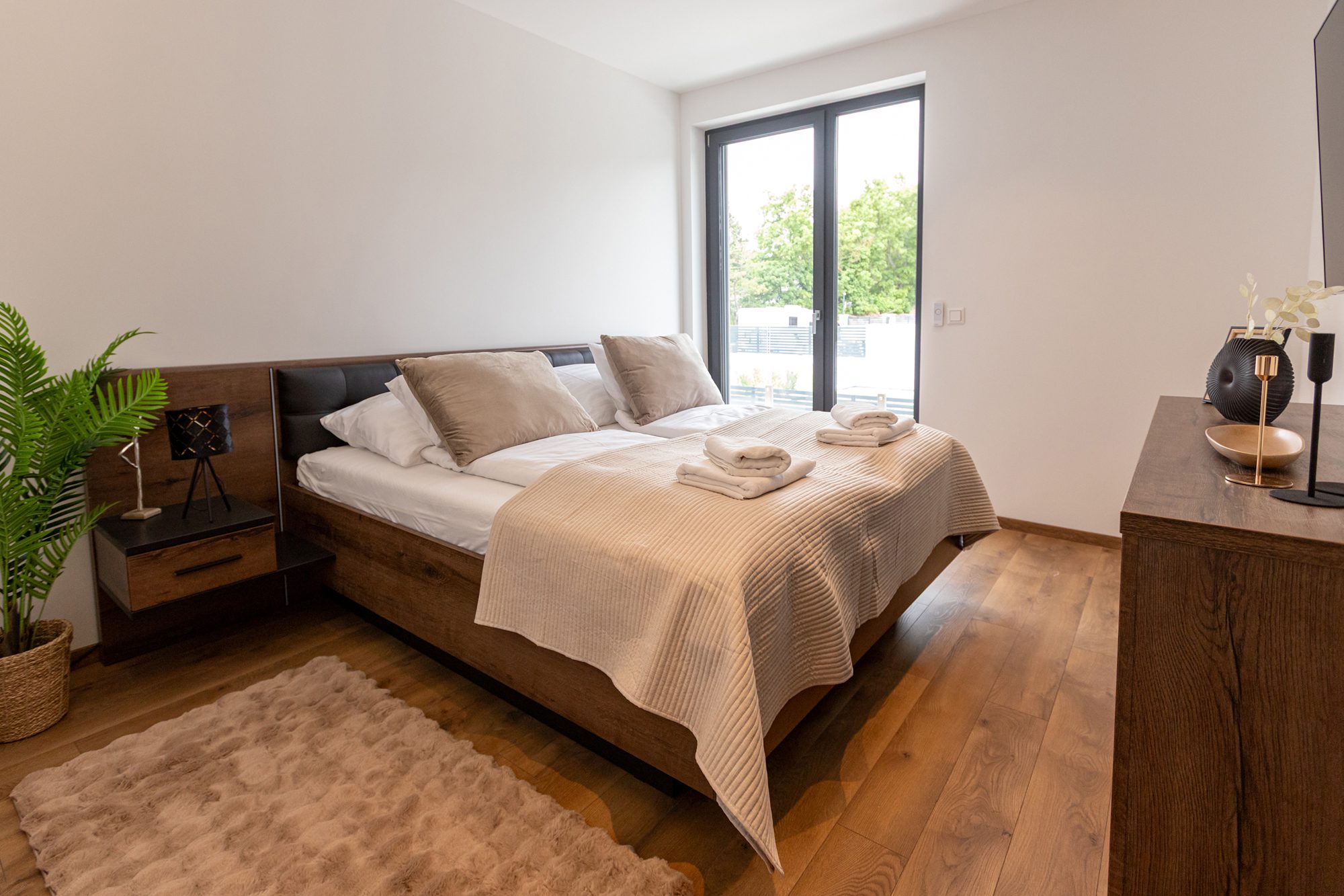 Bedroom villa accommodation Hungary - Villa Porta Verde II bedroom with wooden frame and outdoor garden view