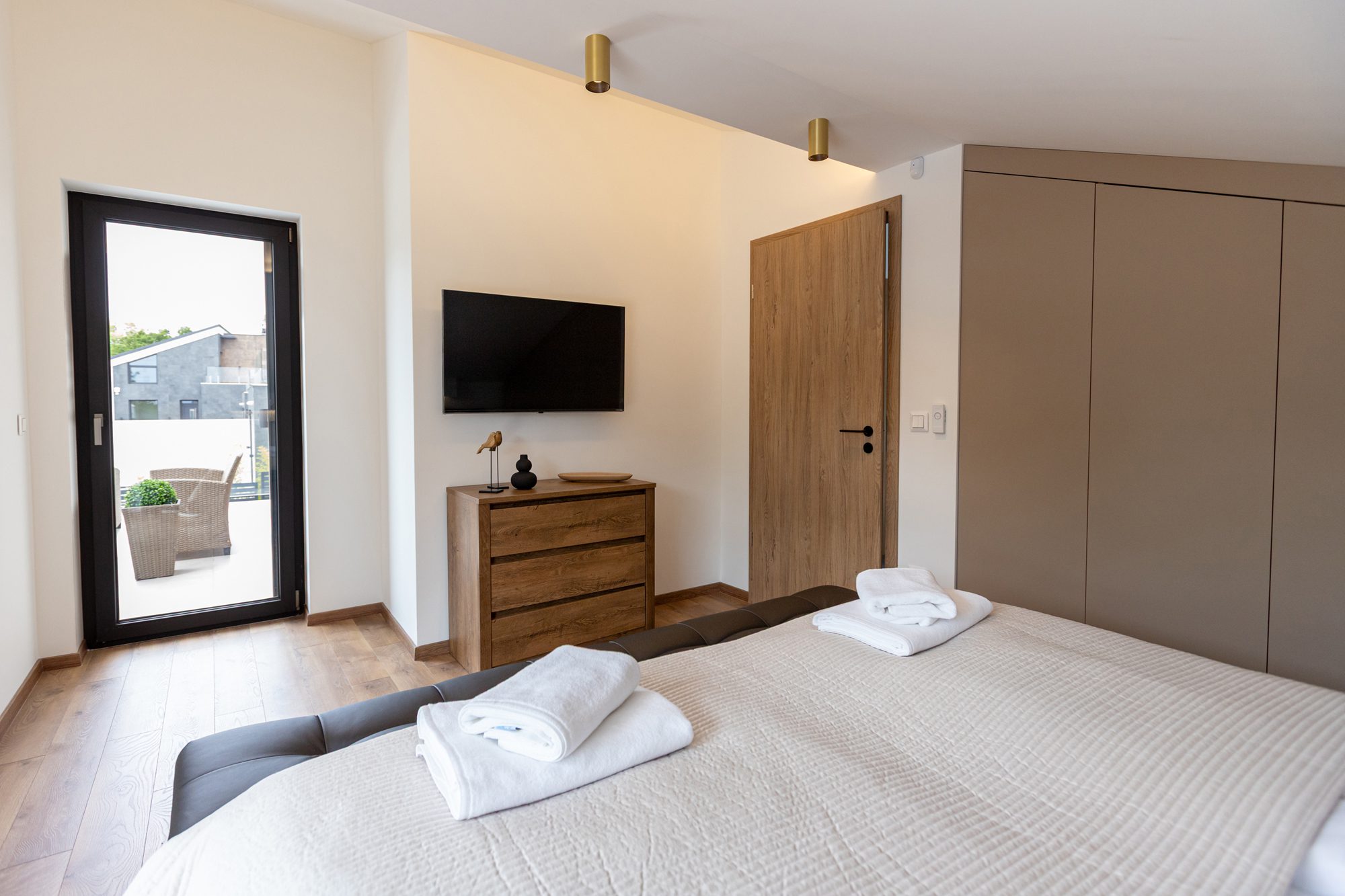 Bedroom villa rental Hungary - Villa Porta Verde II bedroom with dresser, TV and balcony access